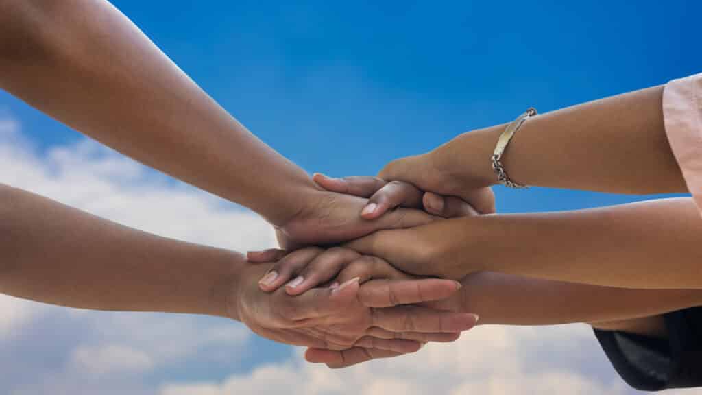 People holding hands, stacked together in friendship.